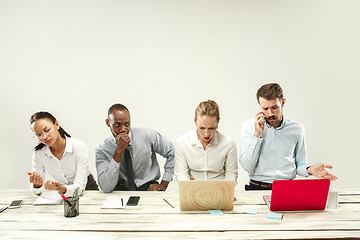 Image showing Young men and women sitting at office and working on laptops. Emotions concept