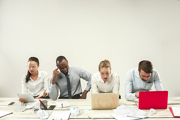 Image showing Young men and women sitting at office and working on laptops. Emotions concept