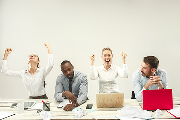 Image showing Young men and women sitting at office and working on laptops. Emotions concept