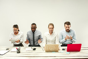 Image showing Young men and women sitting at office and working on laptops. Emotions concept