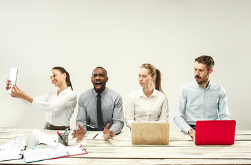 Image showing Young men and women sitting at office and working on laptops. Emotions concept