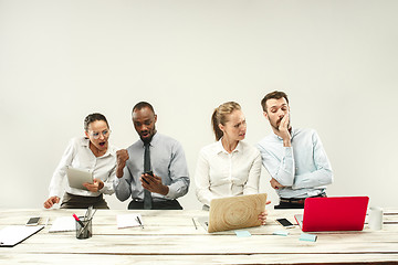 Image showing Young men and women sitting at office and working on laptops. Emotions concept