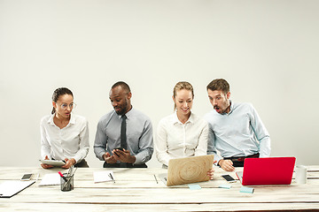 Image showing Young men and women sitting at office and working on laptops. Emotions concept