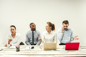 Image showing Young men and women sitting at office and working on laptops. Emotions concept