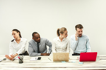 Image showing Young men and women sitting at office and working on laptops. Emotions concept