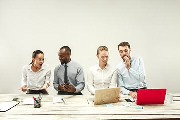 Image showing Young men and women sitting at office and working on laptops. Emotions concept