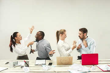 Image showing Young men and women sitting at office and working on laptops. Emotions concept