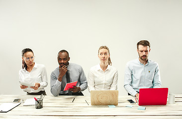 Image showing Young men and women sitting at office and working on laptops. Emotions concept