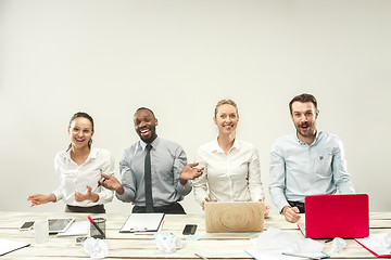 Image showing Young men and women sitting at office and working on laptops. Emotions concept