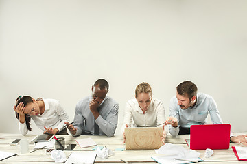 Image showing Young men and women sitting at office and working on laptops. Emotions concept