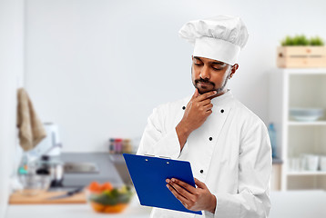 Image showing indian chef reading menu on clipboard at kitchen