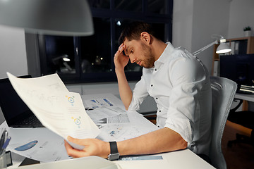 Image showing businessman with papers working at night office