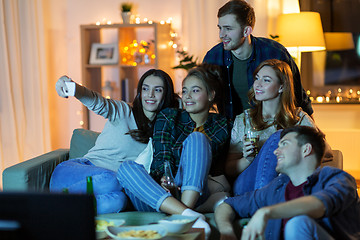 Image showing happy friends taking selfie by smartphone at home