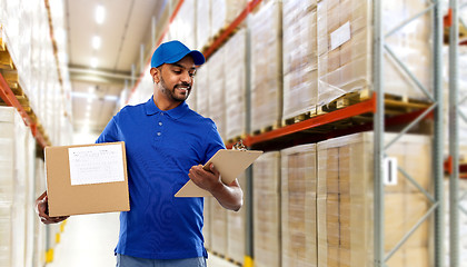 Image showing delivery man with box and clipboard at warehouse