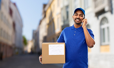 Image showing delivery man with smartphone and parcel in city