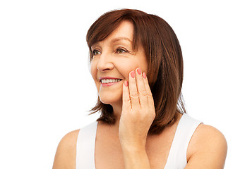 Image showing portrait of smiling senior woman touching her face