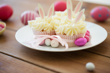 Image showing cupcakes with easter eggs and candies on table