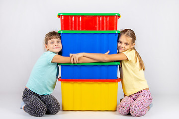 Image showing Two girls hug big plastic boxes