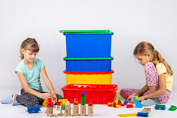 Image showing Two girls play toys, in the middle are boxes with toys