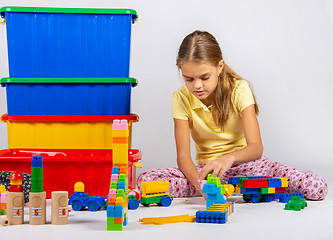 Image showing Ten year old girl playing toys sitting on the floor