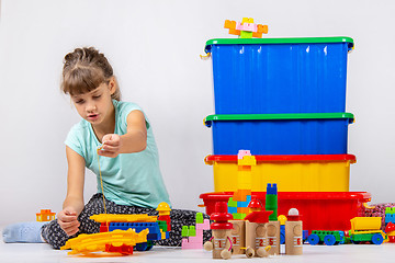 Image showing Girl alone plays constructor and other toys