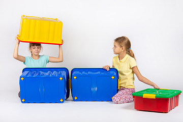 Image showing Two girls play with large plastic boxes