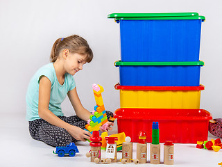 Image showing Girl alone plays toys
