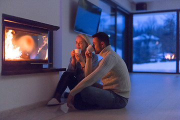 Image showing happy couple in front of fireplace