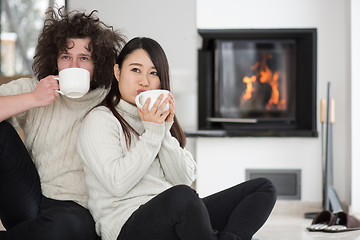 Image showing happy multiethnic couple  in front of fireplace