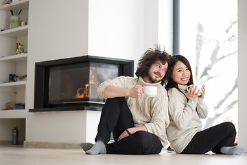 Image showing happy multiethnic couple  in front of fireplace