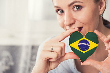 Image showing Young woman with gingerbread heart cookies with flag