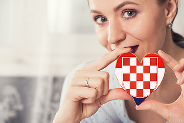 Image showing Young woman with gingerbread heart cookies with flag