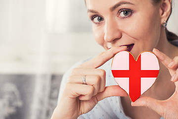 Image showing Young woman with gingerbread heart cookies with flag