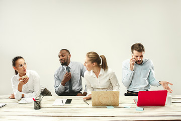 Image showing Young men and women sitting at office and working on laptops. Emotions concept