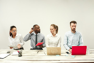 Image showing Young men and women sitting at office and working on laptops. Emotions concept