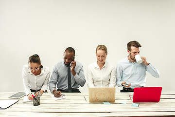 Image showing Young men and women sitting at office and working on laptops. Emotions concept