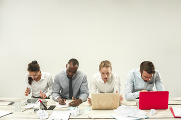 Image showing Young men and women sitting at office and working on laptops. Emotions concept