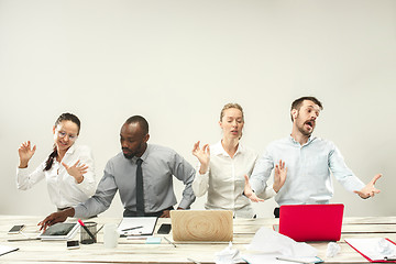 Image showing Young men and women sitting at office and working on laptops. Emotions concept