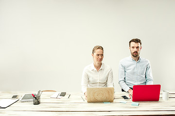 Image showing Young men and women sitting at office and working on laptops. Emotions concept