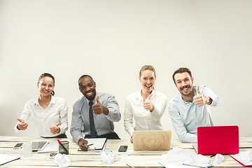 Image showing Young men and women sitting at office and working on laptops. Emotions concept