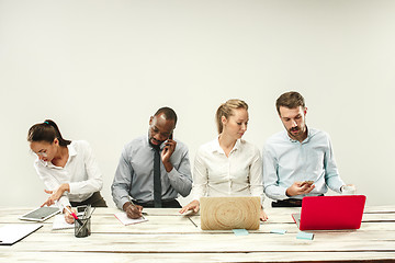 Image showing Young men and women sitting at office and working on laptops. Emotions concept