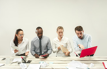 Image showing Young men and women sitting at office and working on laptops. Emotions concept