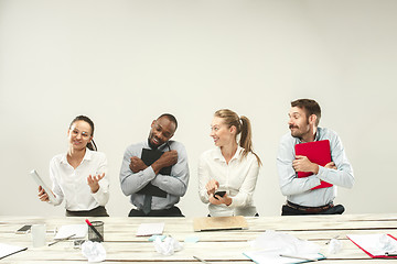 Image showing Young men and women sitting at office and working on laptops. Emotions concept