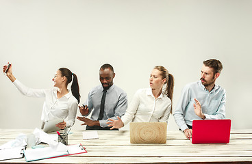 Image showing Young men and women sitting at office and working on laptops. Emotions concept