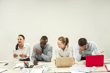 Image showing Young men and women sitting at office and working on laptops. Emotions concept