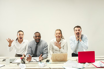 Image showing Young men and women sitting at office and working on laptops. Emotions concept