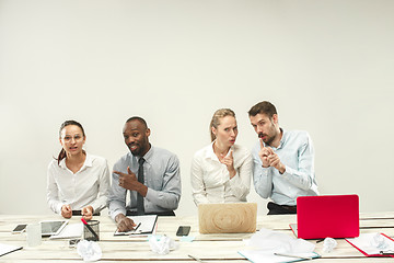 Image showing Young men and women sitting at office and working on laptops. Emotions concept