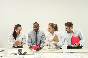 Image showing Young men and women sitting at office and working on laptops. Emotions concept