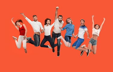 Image showing Freedom in moving. young man and women jumping against red background