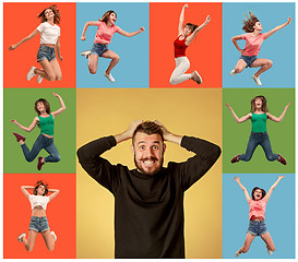 Image showing Freedom in moving. young man and woman jumping against orange background